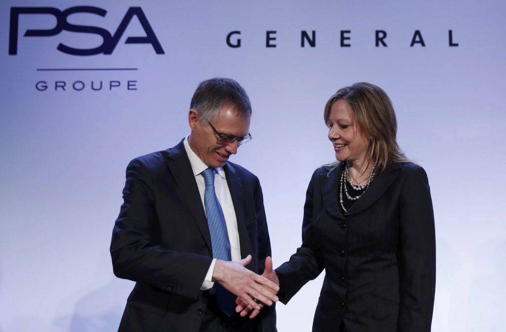 Carlos Tavares, Chairman of the Managing Board of French carmaker PSA Peugeot Citroen, shakes hands with Mary Barra, chairwoman and CEO of General Motors, before a news conference in Paris